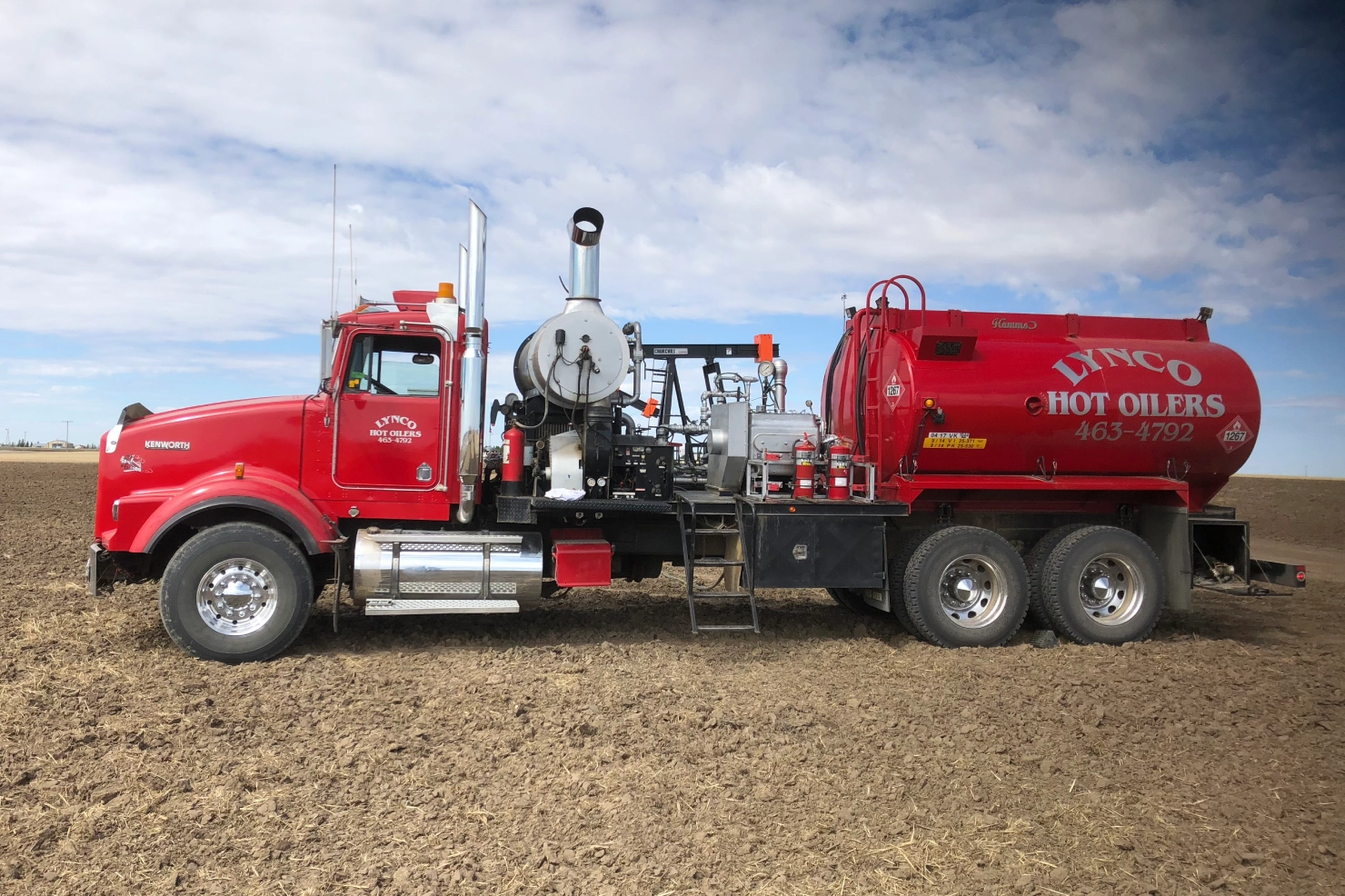 Side view of an oilfield hot oiler truck with visible hose connections